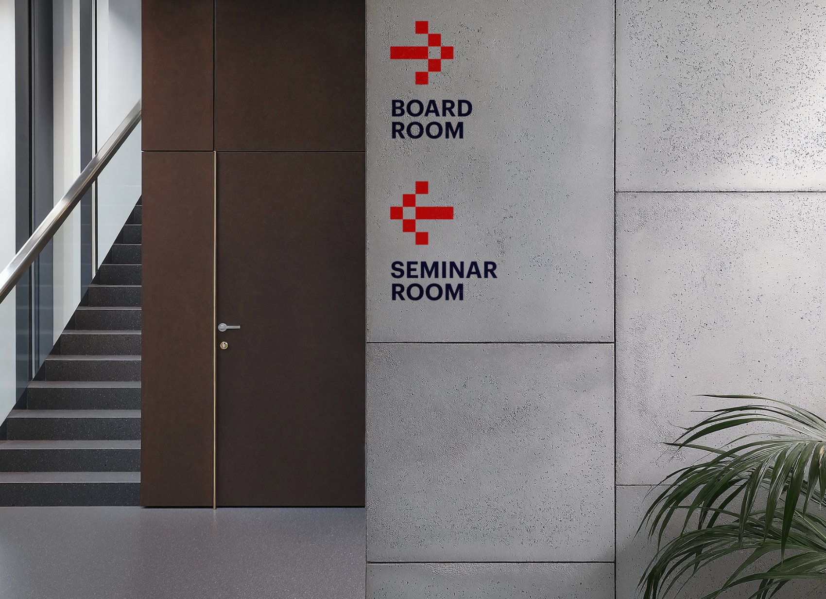 Concrete wall wayfinding signage with red pixel icons for Board Room and Seminar Room